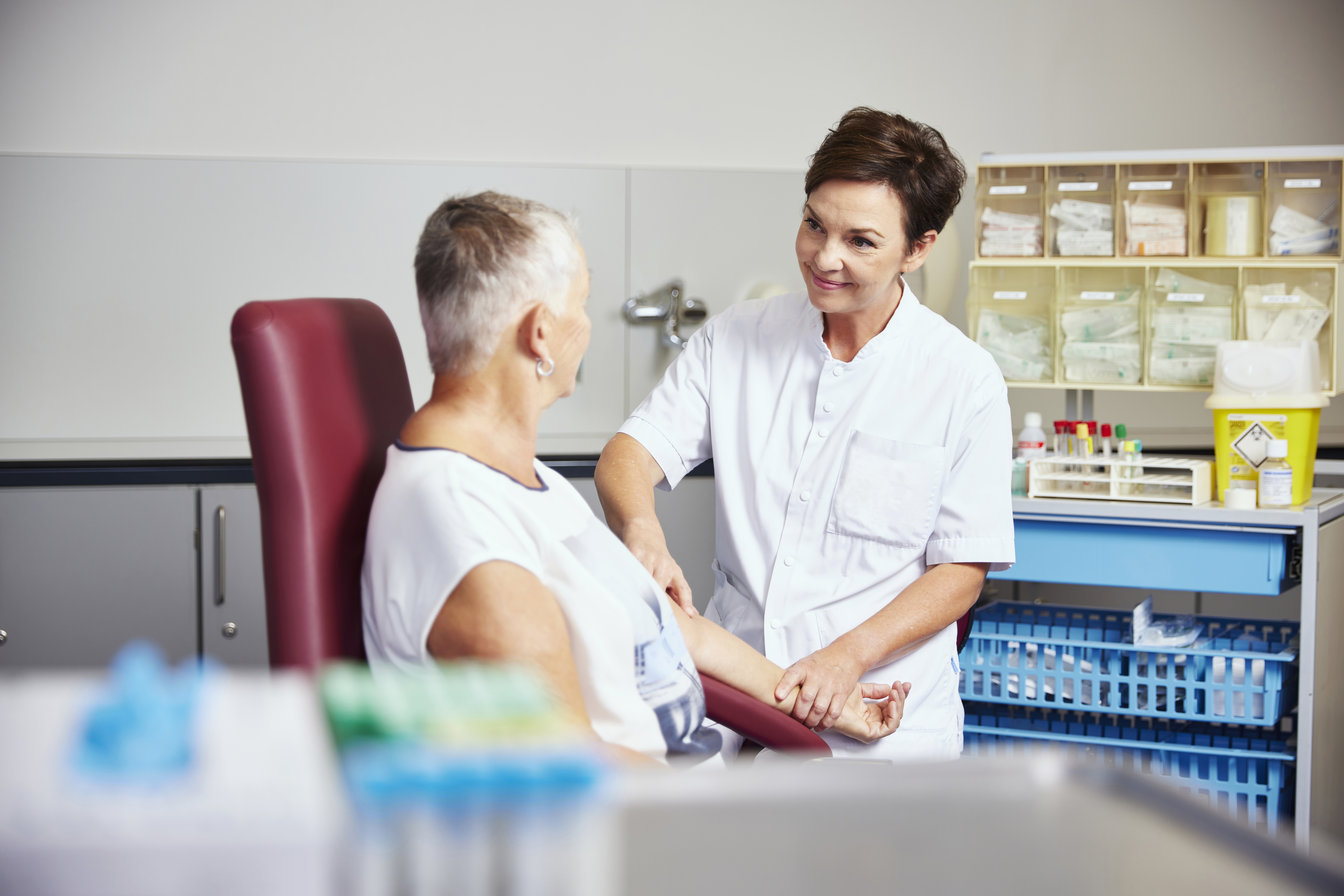 Vrouwelijke arts bloedprikken bij patiënt